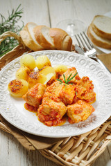 Meat stew with baked potatoes on white plate