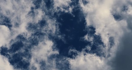 Dramatic clouds moving over blue sky background, changing from white to dark. 4K UHD timelapse.