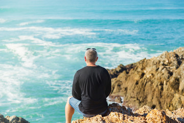 Man enjoy sea view on the rock