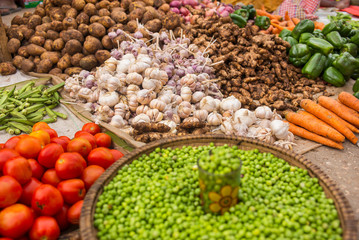 garlic, tomatoes, potatoes and other colored vegetables on the floor on market