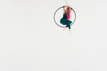 Aerial acrobat in the ring. A young girl performs the acrobatic elements in the air ring.