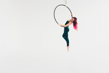 A young girl performs the acrobatic elements in the air ring. Studio shooting performances on a...