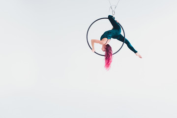 A young girl performs the acrobatic elements in the air ring. Studio shooting performances on a...