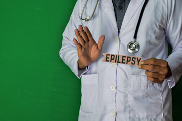 A doctor standing, Hold the Epilepsy paper text on Green background. Medical and healthcare concept.