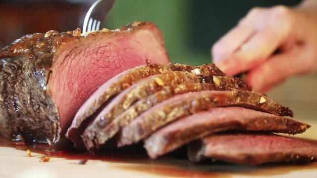 Cutting slices of roasted beef