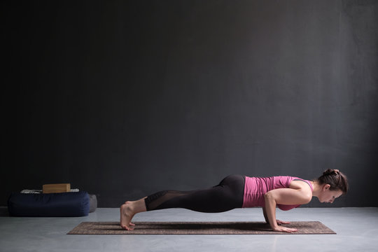 Woman practicing yoga, standing in chaturanga dandasana exercise