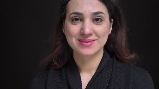 Closeup portrait of young attractive caucasian female cheerfully smiling and raising her eyebrows up looking at camera