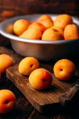 Mellow apricots with knife over cutting board
