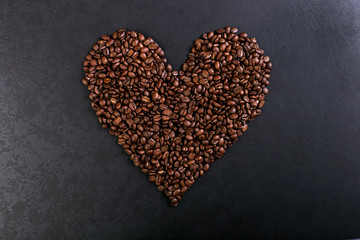 Aroma roasted coffee beans on rustic tabletop, brown banner background, shape of a heart.