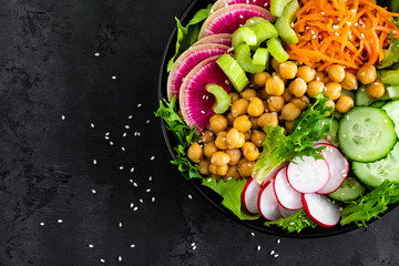 Salad Buddha bowl with fresh cucumber, celery, watermelon radish, raw carrot, lettuce, radish and chickpea for lunch. Healthy vegetarian food. Vegan vegetable dish. Top view