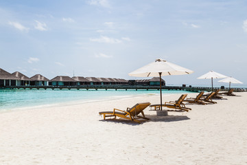 Beach chairs with a view of clear blue water in the Maldives