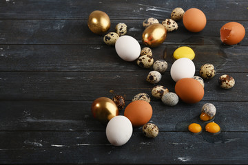 Different size quail and chicken eggs on a wooden surface. Horizontal.