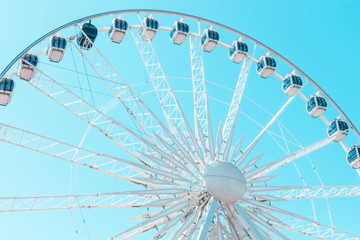 White ferris wheel on a blue pastel  sky background