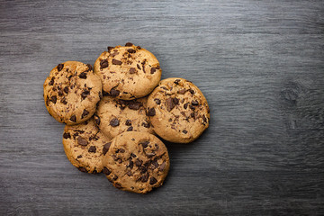 GALLETAS CON VIRUTAS DE CHOCOLATE SOBRE MESA DE MADERA GRIS
