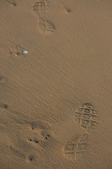 Shoes footprints on sand background.