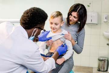 portrait of a little boy being checked by a doctor using a stethoscope