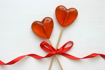 Romantic Valentine`s day background. Lollipops in the shape of heart close up  on white background. Copy space.