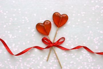 Romantic Valentine`s day background. Lollipops in the shape of heart close up  on white background. Copy space.