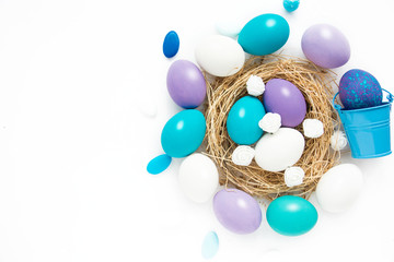 azure, purple, pastel colored Easter eggs in nest on white background, selective focus image. Happy Easter card 