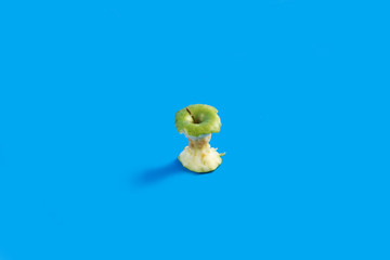  green Apple on blue background. Apple bitten