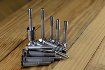 Bolts with nuts and washers on wooden board