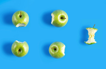  green Apple on blue background. Apple bitten