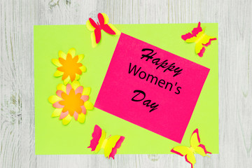 Handmade greeting card made of colored paper and wish Happy Women's Day. Flat lay