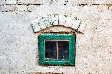 A small window in the brick wall of the chicken coop