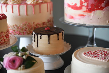 Group of decorated cakes displayed on cake stands
