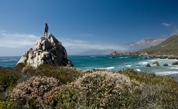 Woman stands on top of outcropping