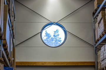 View on trees through round window of warehose. Beautiful backgrounds. 
