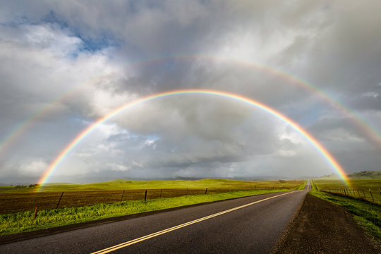 Double rainbow over a rural road