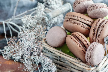 Delicate almond meringue macaroons in a wicker basket on the table. Close-up