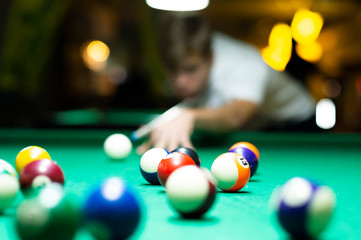 Young man playing pool in pub