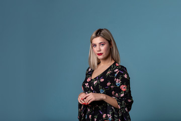 Beautiful young girl with bright lips and blonde hair posing in studio