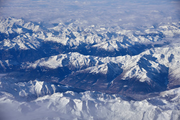 Fototapeta premium Aerial view of the rugged snow covered mountains of the Alps at the junction of Italy, France and Switzerland 