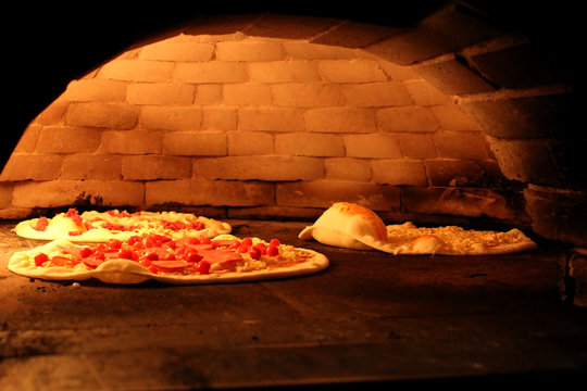 Pizza baking close up in the oven. Image of a brick pizza oven.