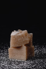 peaces of Pelamushi with sugar dust, powder - Gerogian traditional sweet dessert. Cooked porridge with condensed grape juice, corn and white flour, walnuts. Georgian food. Also called tatara