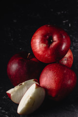 Red apples and slices of apples. Dark. Baton background. Photo in low key