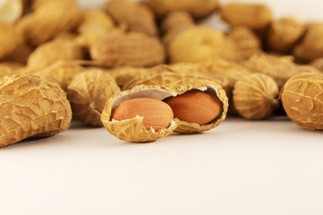 Peeled peanuts on well peanuts in background. Macro image
