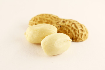 Peeled peanuts in closeup, isolated on white background