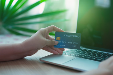 Business and financial concepts. Asian businesses hold credit cards for online purchases via mobile phones, laptops and pay with online banking via credit cards - images.