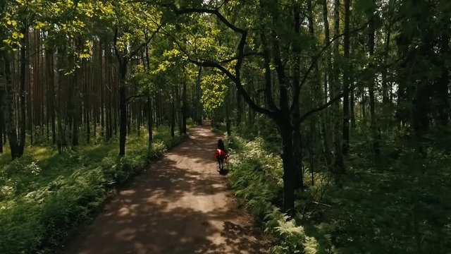 Woman In A Black Cape Riding A Horse In Forest