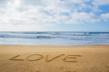 Fototapeta na wymiar word love written on sand on the beach near the ocean in Portugal