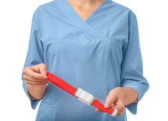 Female doctor holding tourniquet on white background, closeup. Medical object
