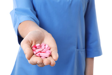 Female doctor holding pills on white background, closeup. Medical object
