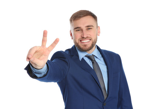 Young businessman celebrating victory on white background