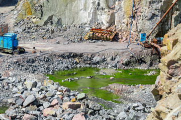 View of quarry open pit mining of granite stone. Process production stone and gravel. Pumping groundwater in the quarry.