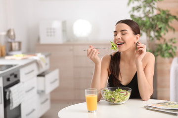 Young woman in fitness clothes having healthy breakfast at home. Space for text