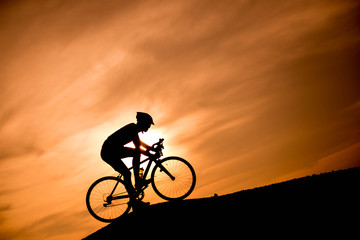 Fototapeta premium Silhouette cyclist at sunset.